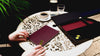 Video featuring crimson red Triptych A5 notebook and black arch folio on a table outside.
